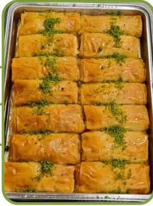 Sütlü börek sarma — creamy milk pastry rolls topped with pistachio.
