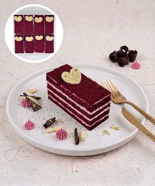 Layered red velvet slice cake with white cream.