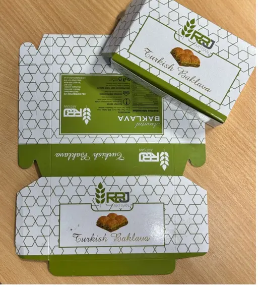 White and green presentation carton for baklava with a honeycomb design.